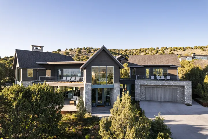 Modern architectural design featuring dark siding and natural stone accents