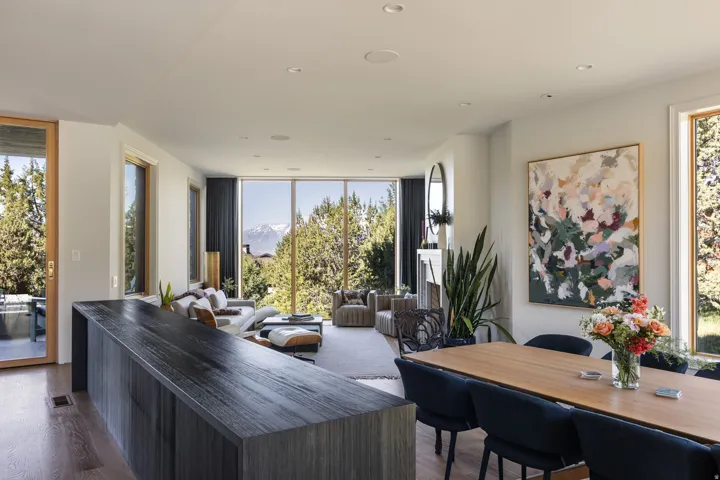 Spacious open-concept interior featuring large picture windows, light wood-finish flooring, and recessed ceiling lighting