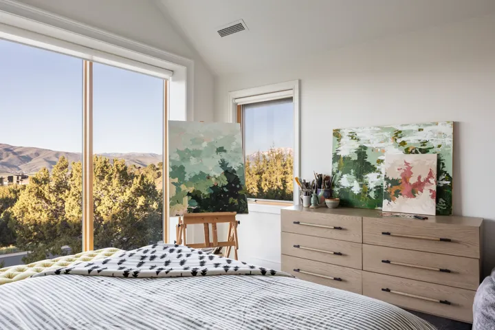 Expansive floor-to-ceiling windows with natural wood framing offer abundant natural light and mountain scenery