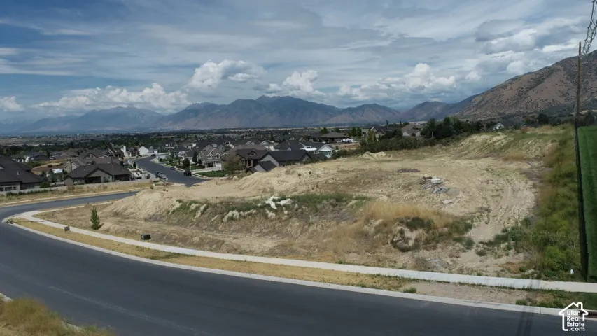 Expansive land parcel featuring partial grading and a paved street with an integrated sidewalk