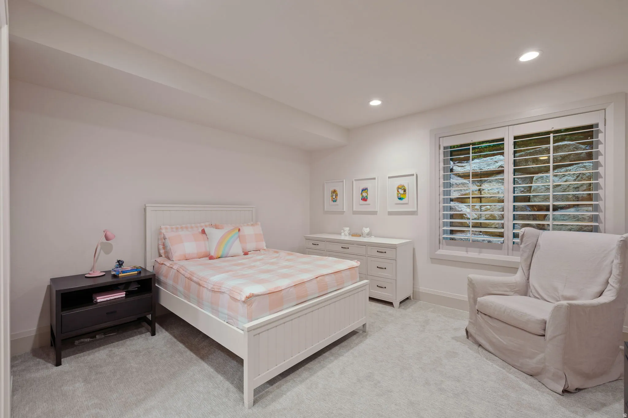 Bedroom featuring light gray carpeting, recessed lighting, and a window with white plantation shutters