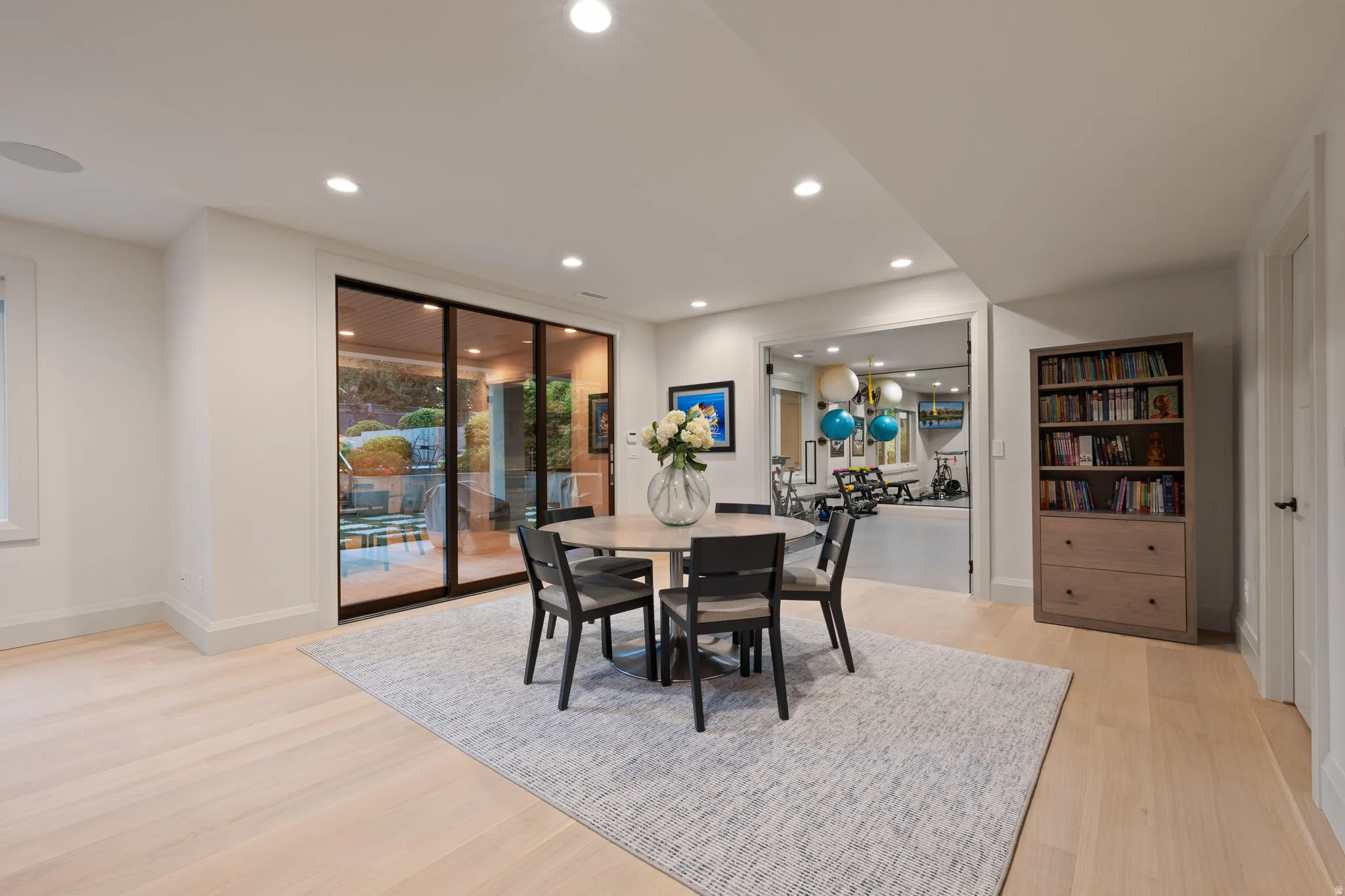 Spacious interior with light wood-finish flooring, recessed lighting, and white baseboards