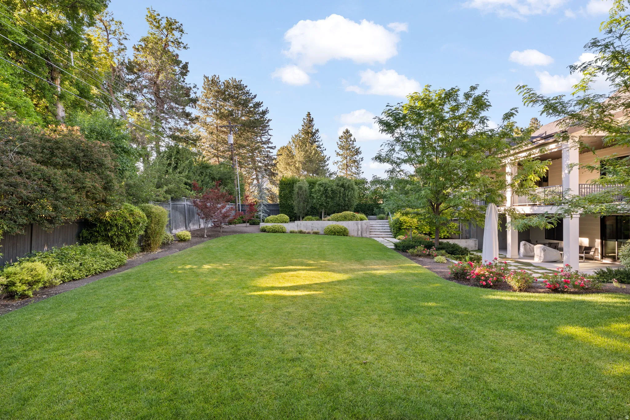 Expansive lawn area bordered by established landscaping