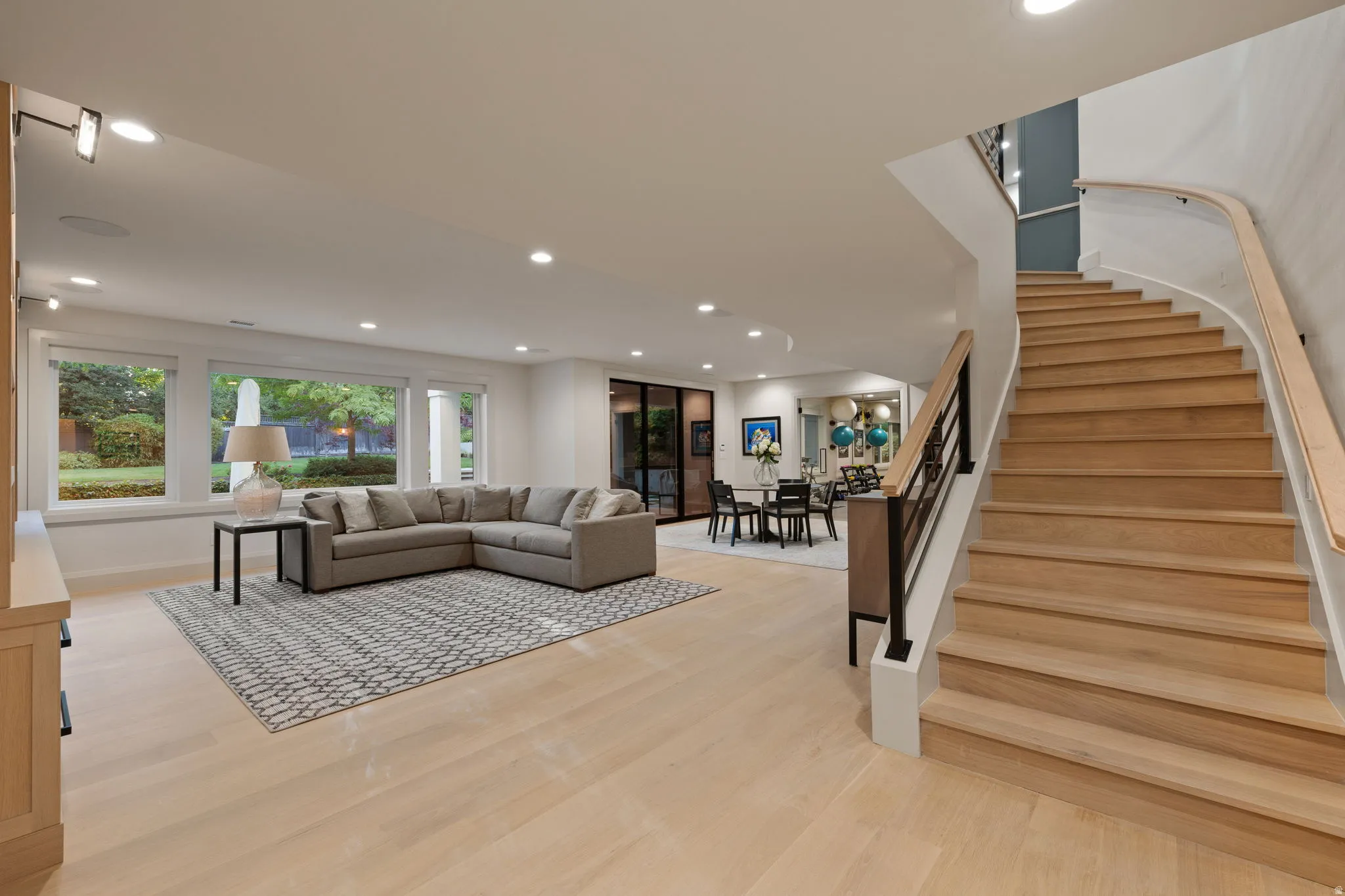 Sweeping curved staircase with wood treads and a contrasting black metal railing