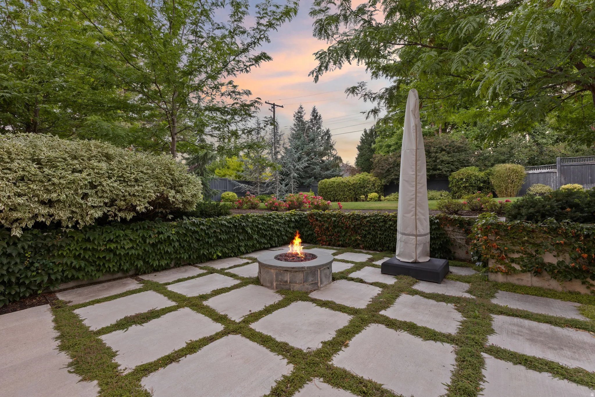 Expansive patio featuring large concrete pavers with interspersed ground cover