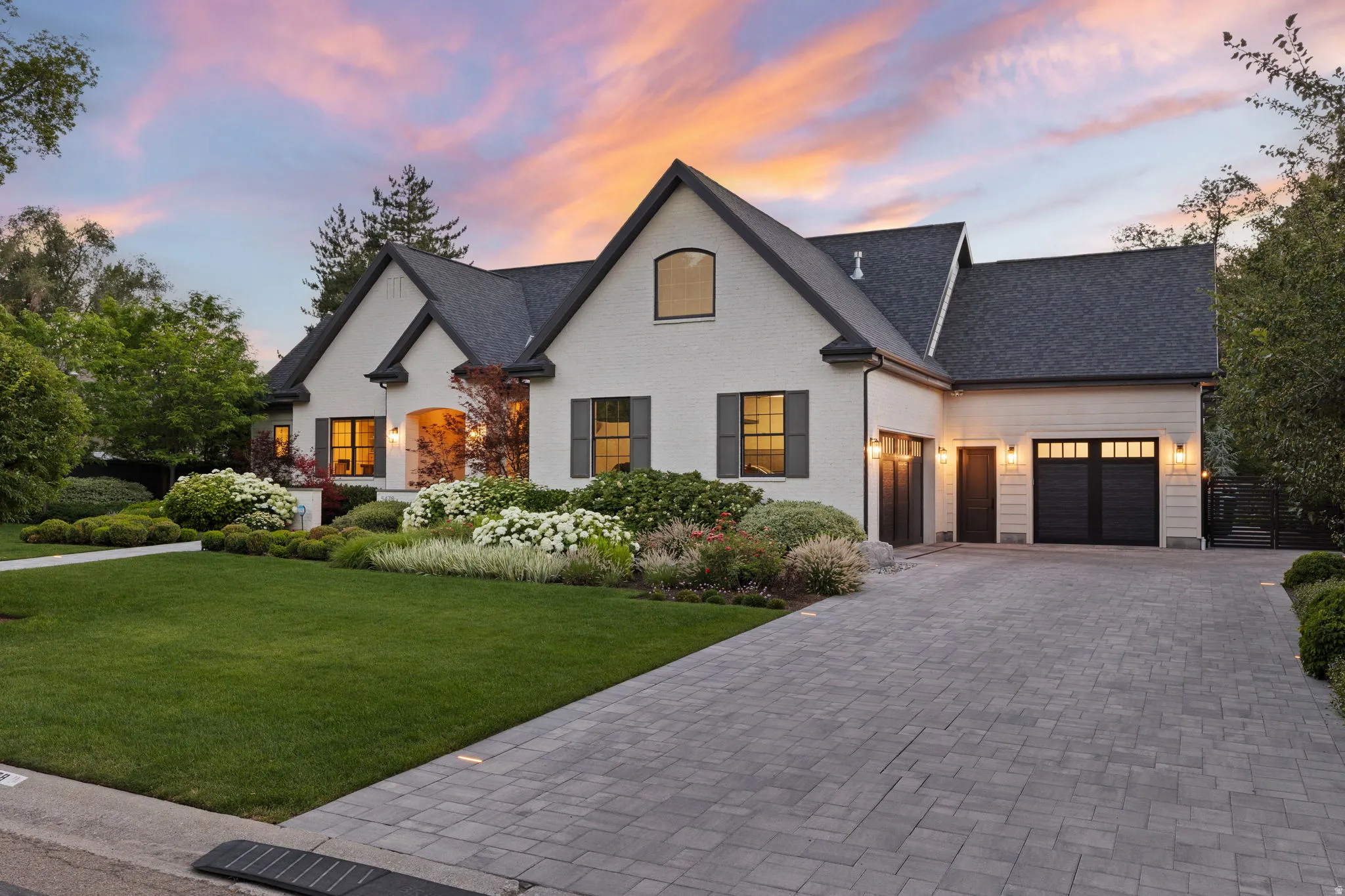 White brick exterior with dark shingle roof and contrasting dark shutters
