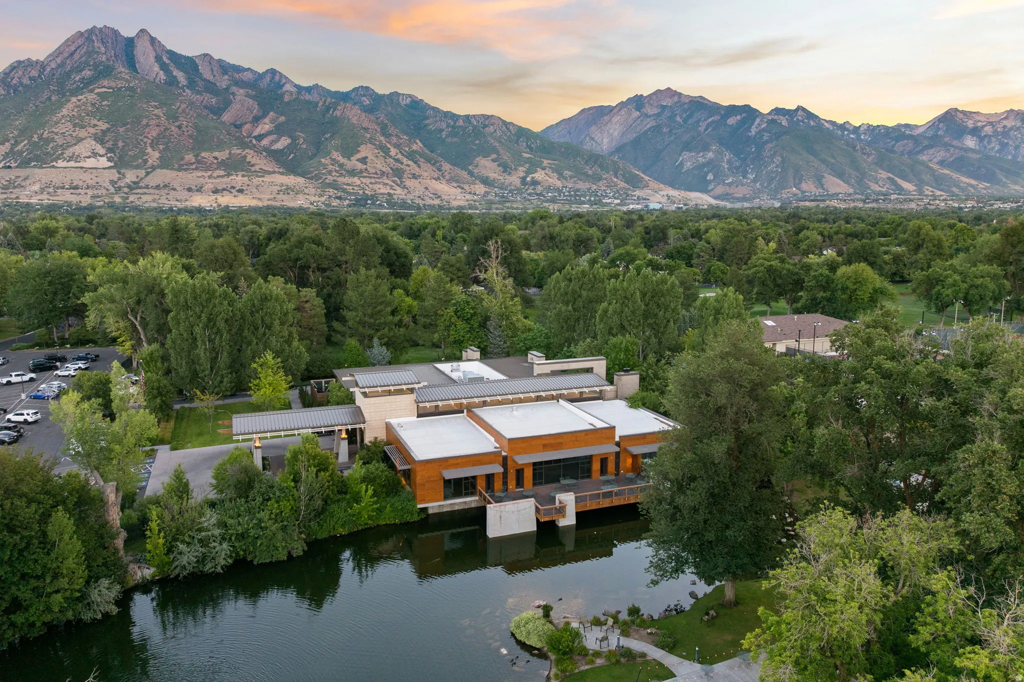Modern architecture property featuring wood paneling and flat roofs, situated on a serene body of water