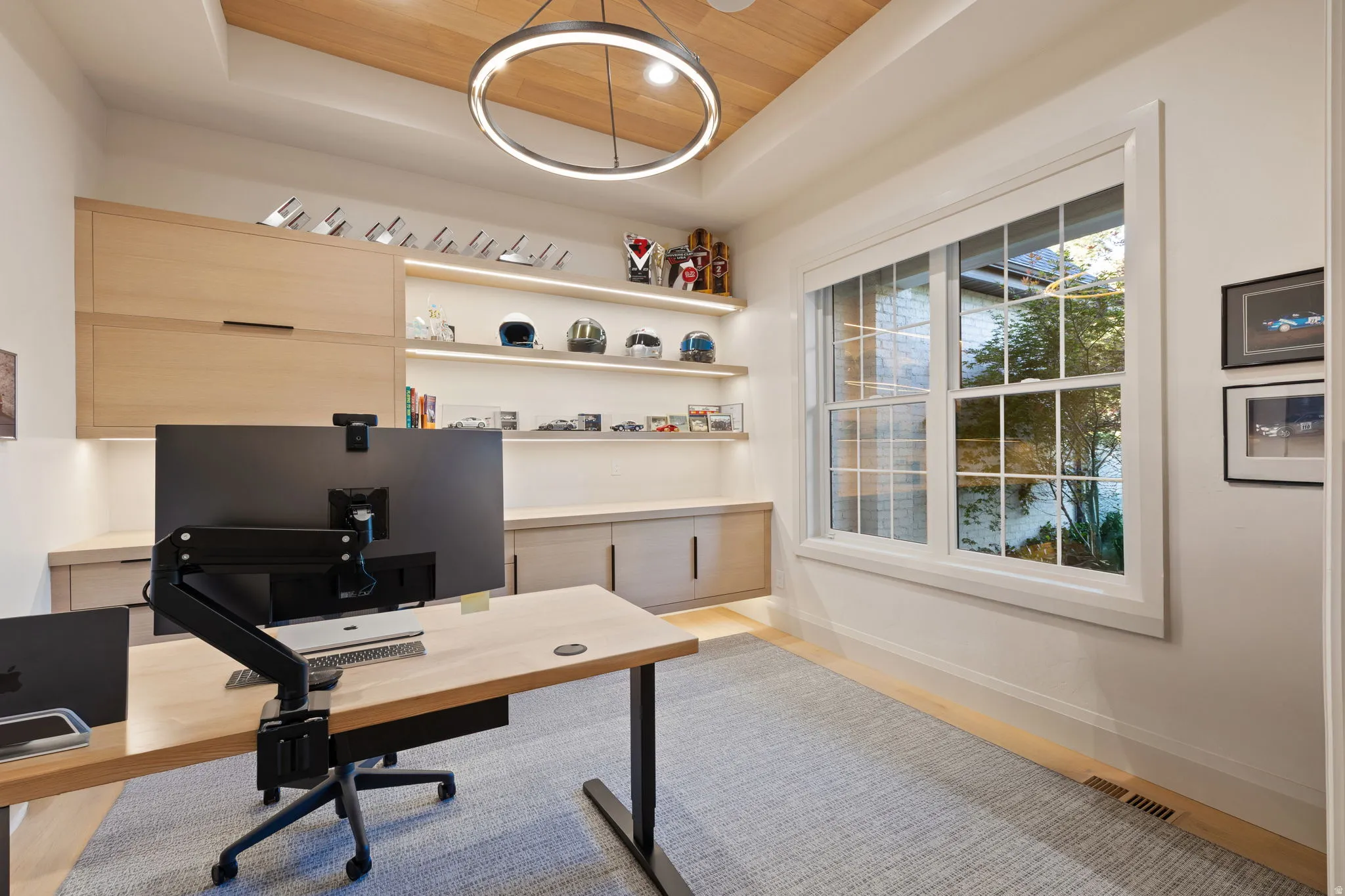 Recessed ceiling with wood-finish paneling and an illuminated circular chandelier