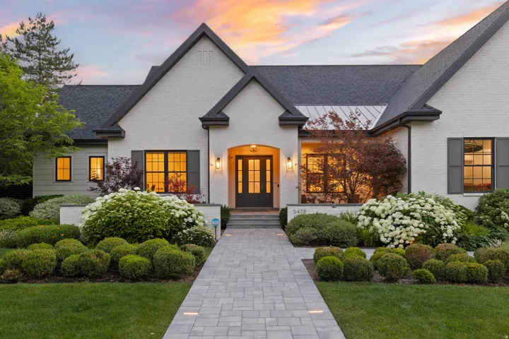 White brick and dark-trim exterior with a gabled roofline