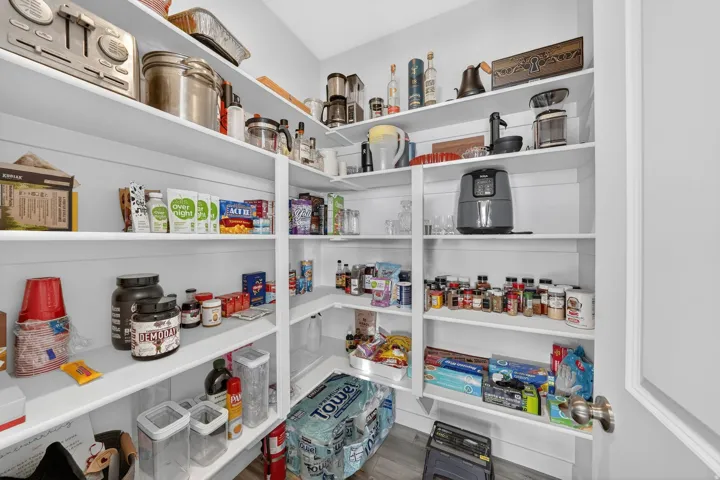 Custom-built pantry with extensive shelving, white finishes, and ample storage space