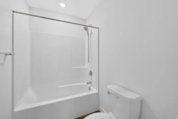 White shower-tub combination featuring a chrome showerhead and faucet
