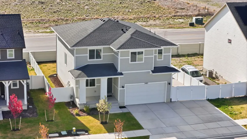 Two-story residence featuring a light gray exterior with white trim accents and a dark shingle roof