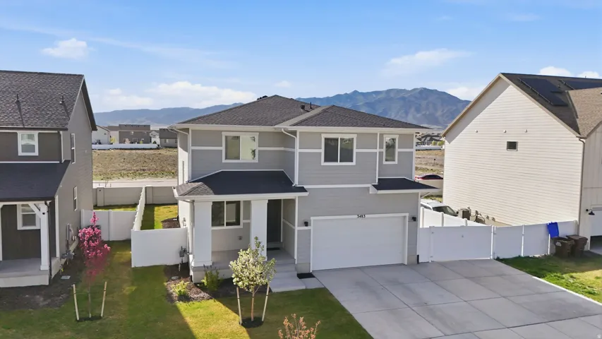 Two-story residence featuring light gray siding, white trim, and a dark shingled roof