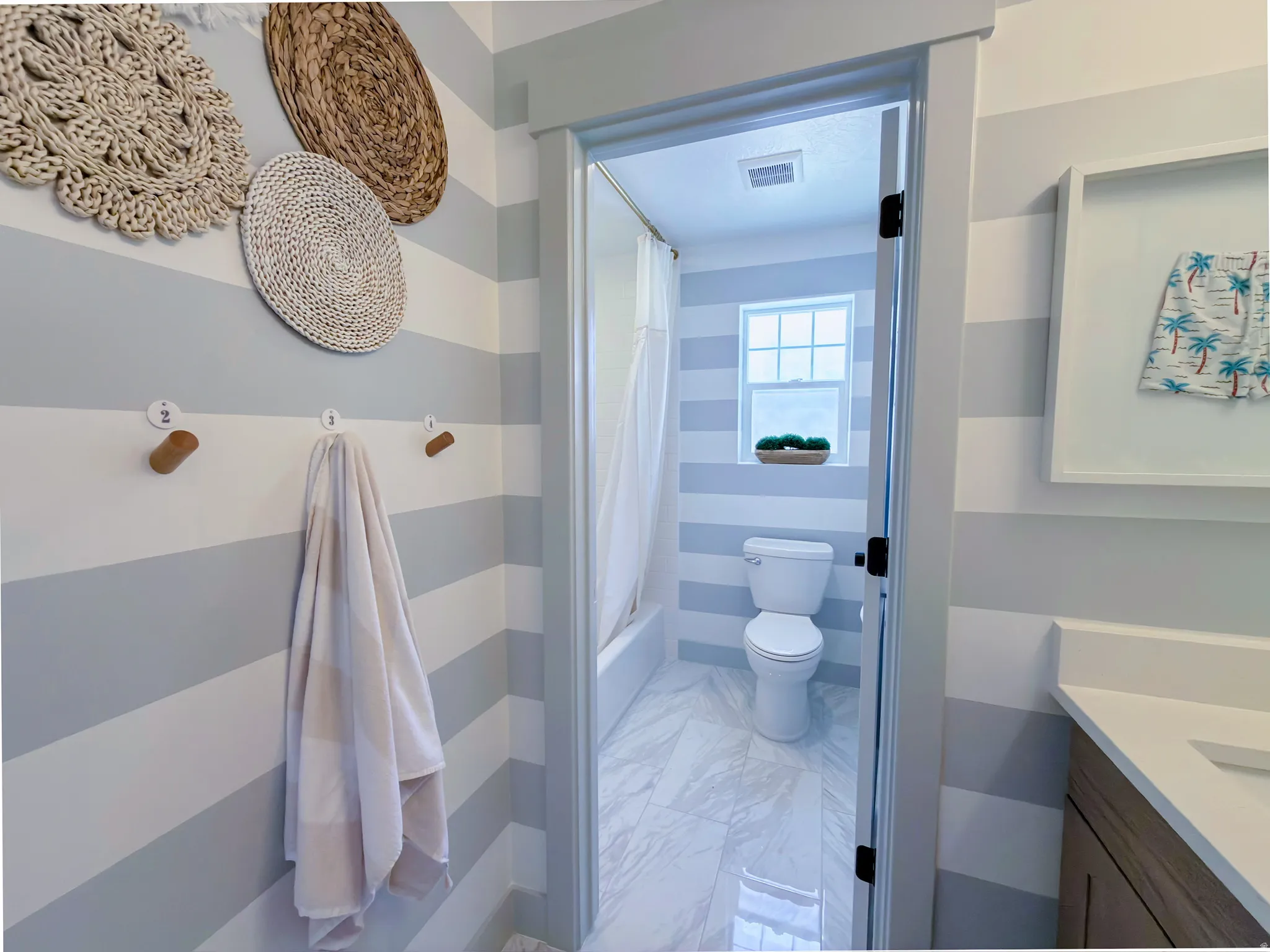 Full bathroom featuring a white porcelain toilet, a shower/tub combination with a white curtain, and a rectangular window