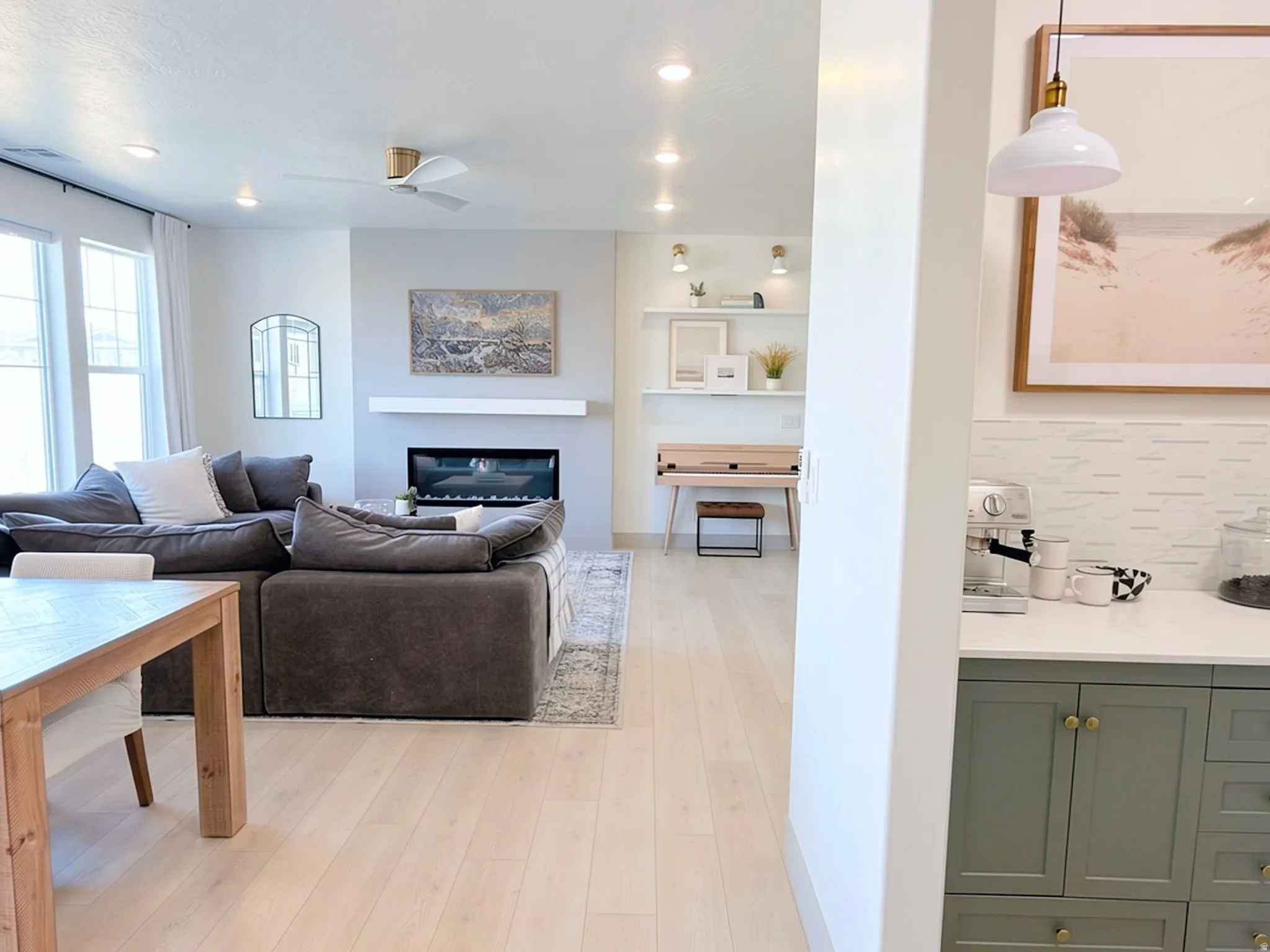Living area featuring light wood-finish flooring, recessed lighting, and a modern fireplace with a floating mantel