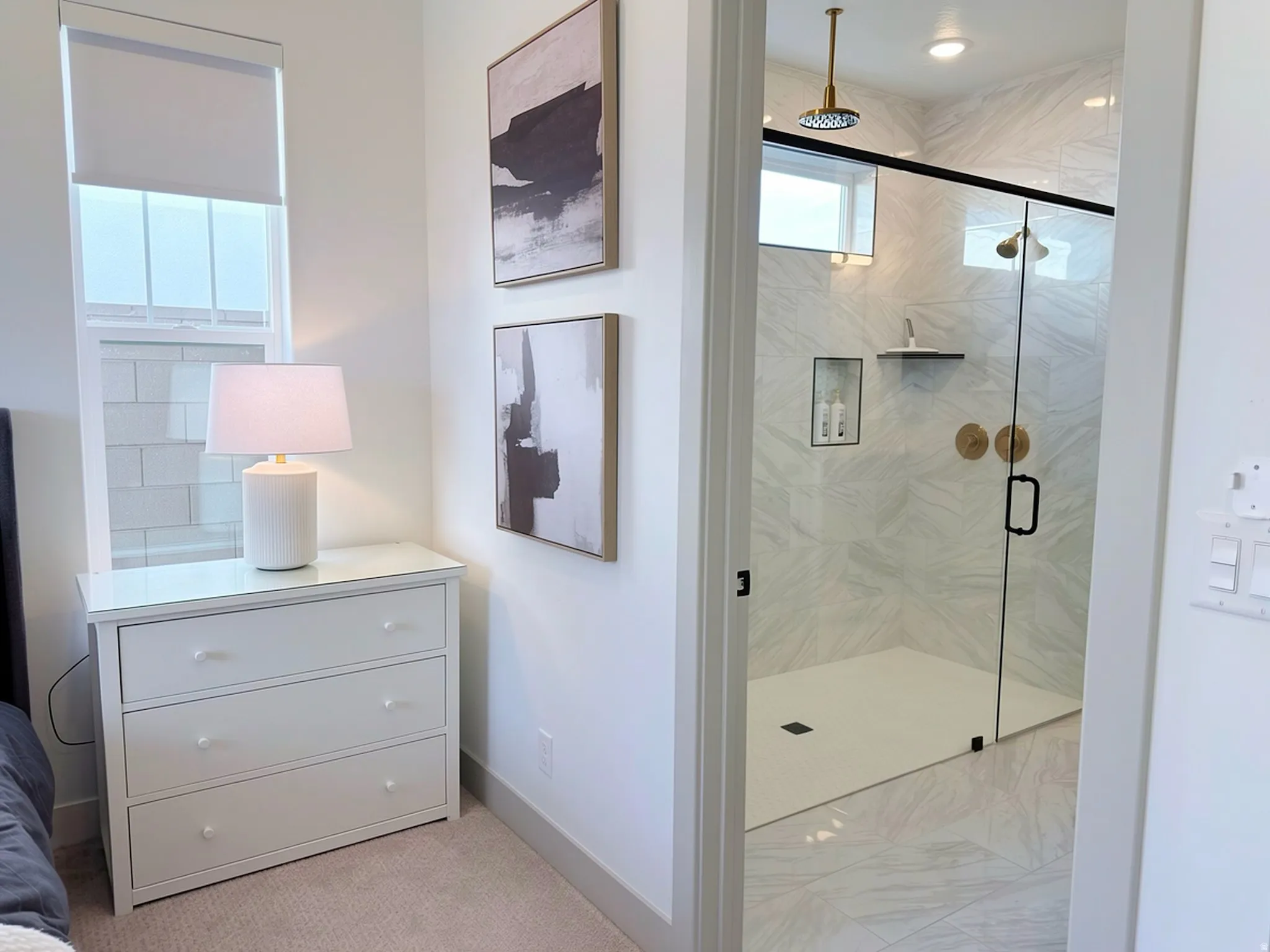 Spacious shower enclosure with floor-to-ceiling marble-look tile, a rain showerhead, and a fixed glass panel with a hinged door