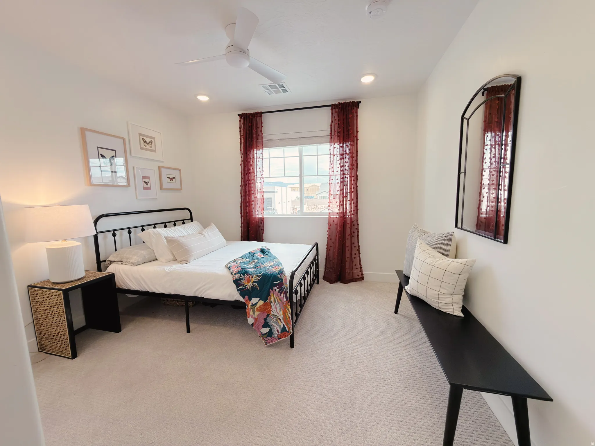 Bedroom featuring light-toned carpet flooring, a window with dark red sheer curtains, recessed lighting, and a ceiling fan