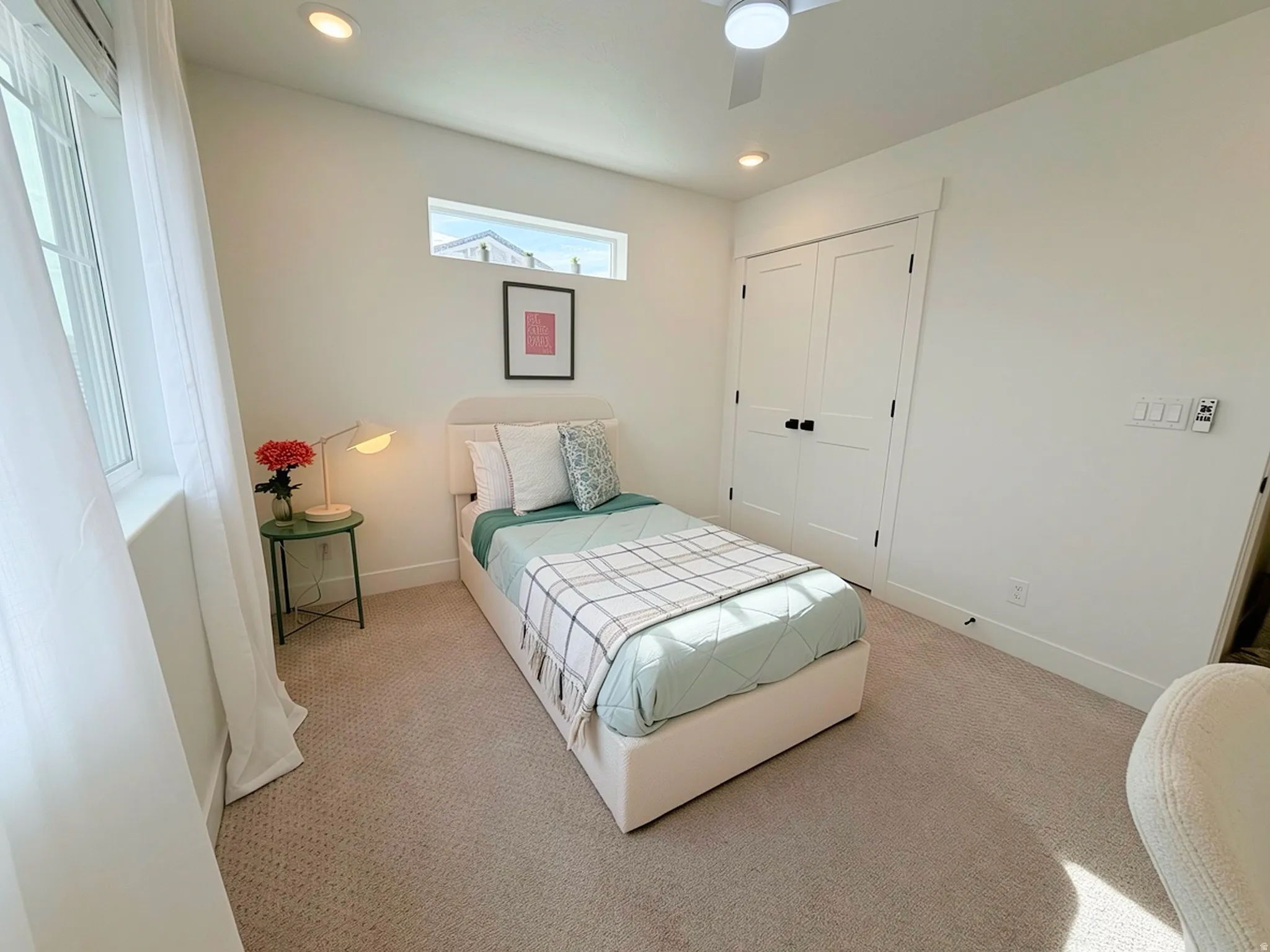 Carpeted room featuring a ceiling fan, recessed lighting, double-panel closet doors with matte black hardware, a large window, and a high horizontal window