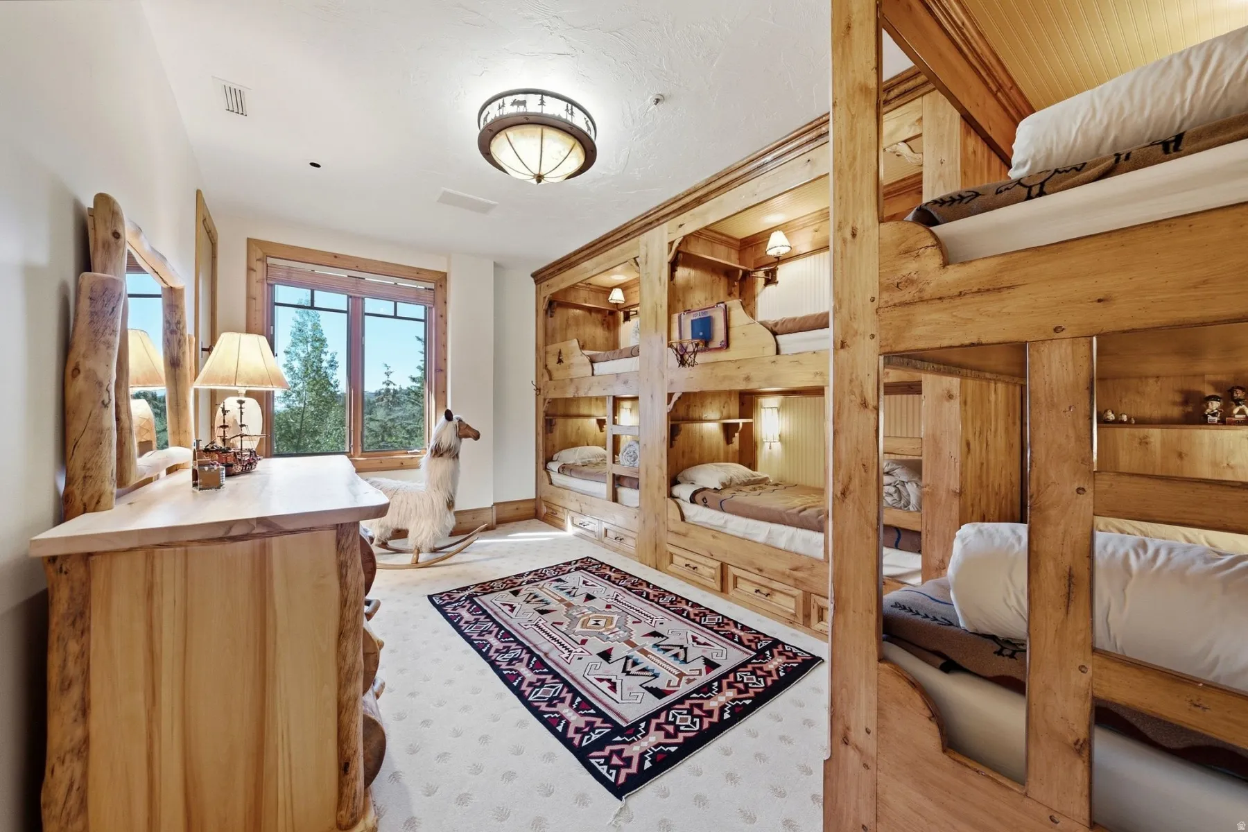 Room featuring built-in wooden bunk beds with individual lighting and storage drawers