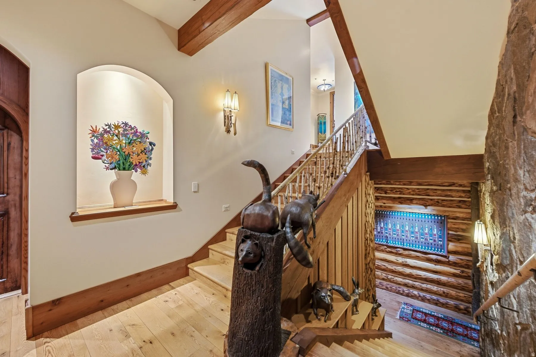 Staircase featuring wood-finish treads and risers, natural wood railings, and exposed wood ceiling beams