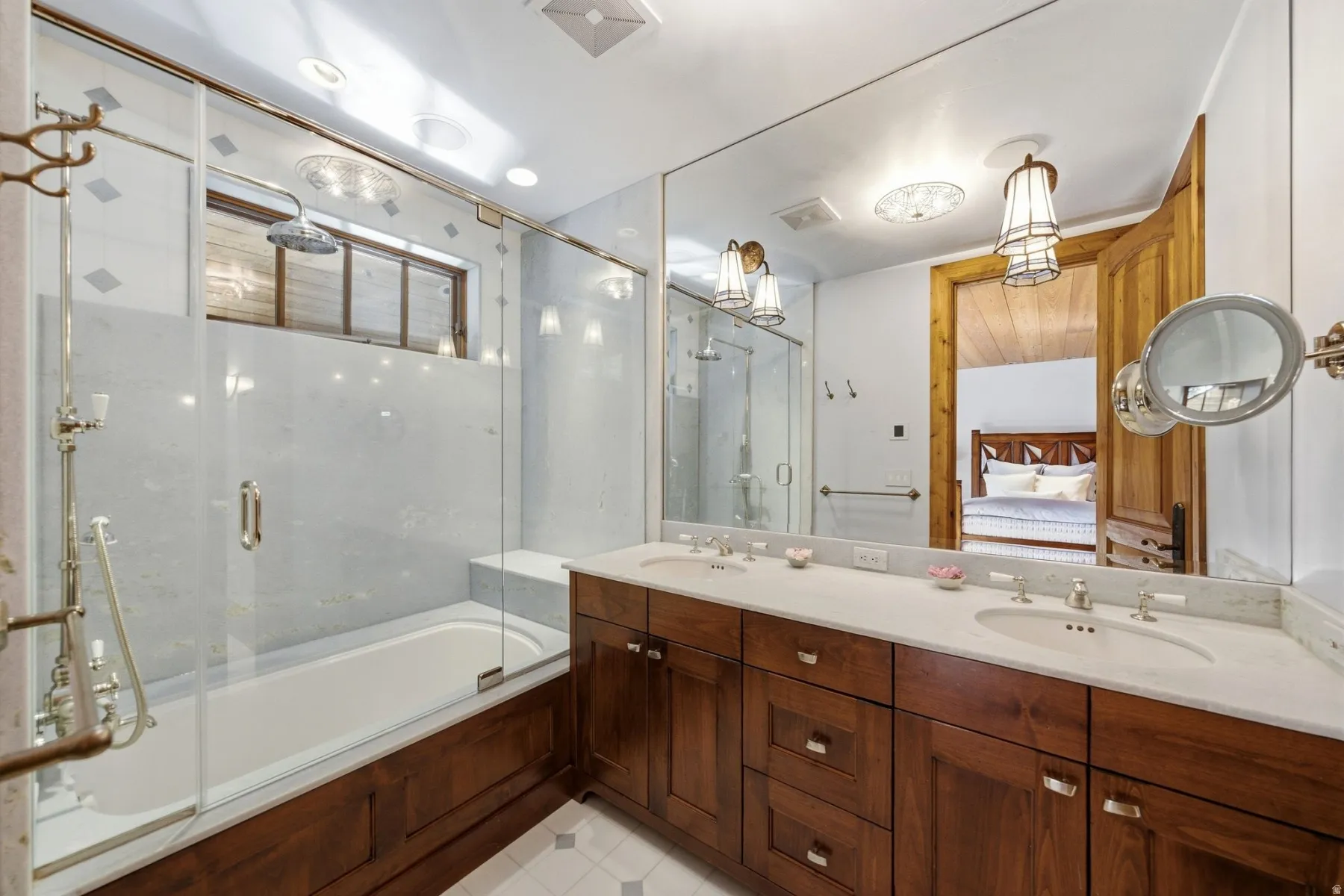 Bathroom featuring a double vanity with stone countertops, integrated sinks, and brass-tone fixtures