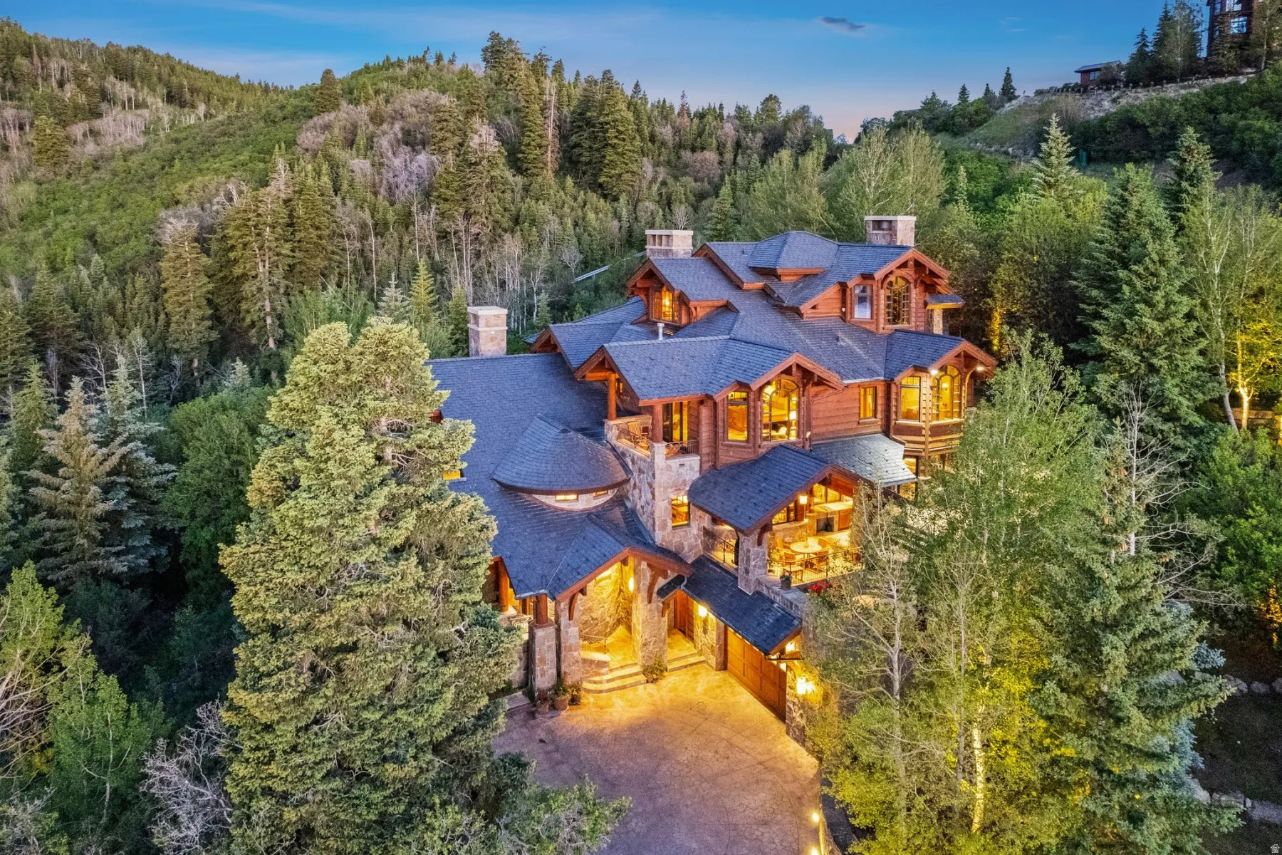 Wood-sided mountain residence featuring a multi-gabled roofline and natural stone accents