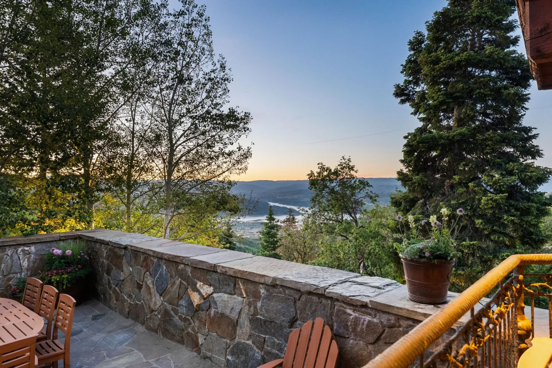 Stone-clad patio with flagstone flooring, solid stone wall, and metal railing
