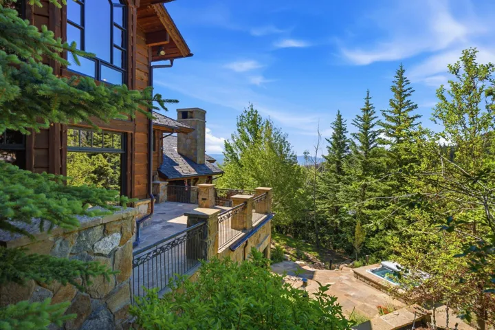 Multi-level outdoor patio with stone retaining walls and ornate metal railings
