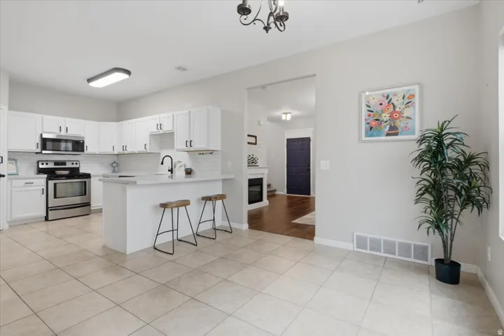 Kitchen with white cabinetry, stainless steel appliances, and a subway tile backsplash