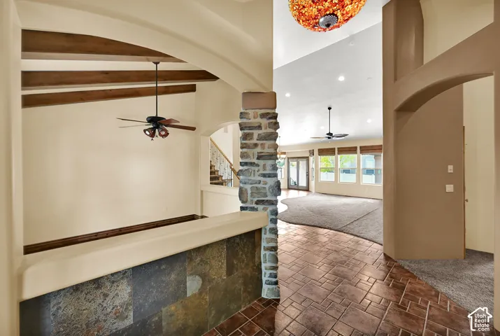 Entryway featuring stamped tile flooring, a stone-clad pillar, and arched doorways