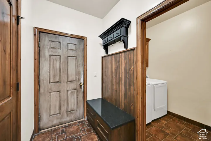 Entryway featuring wood-finish flooring, a four-panel door with wood trim, and a built-in wooden bench with a dark countertop