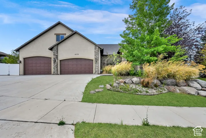 Stucco exterior with stone accents and dual garage doors