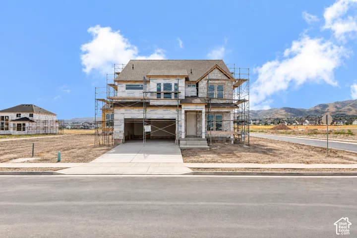 New construction residence featuring a two-car garage, stone and siding exterior, and a concrete driveway