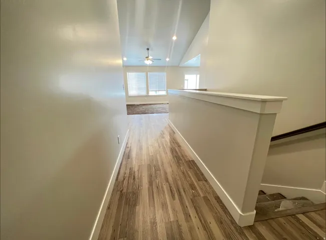 Hallway featuring wood-finish flooring and neutral wall tones