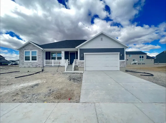 Modern ranch-style home featuring a two-tone exterior with light stone accents and dark siding