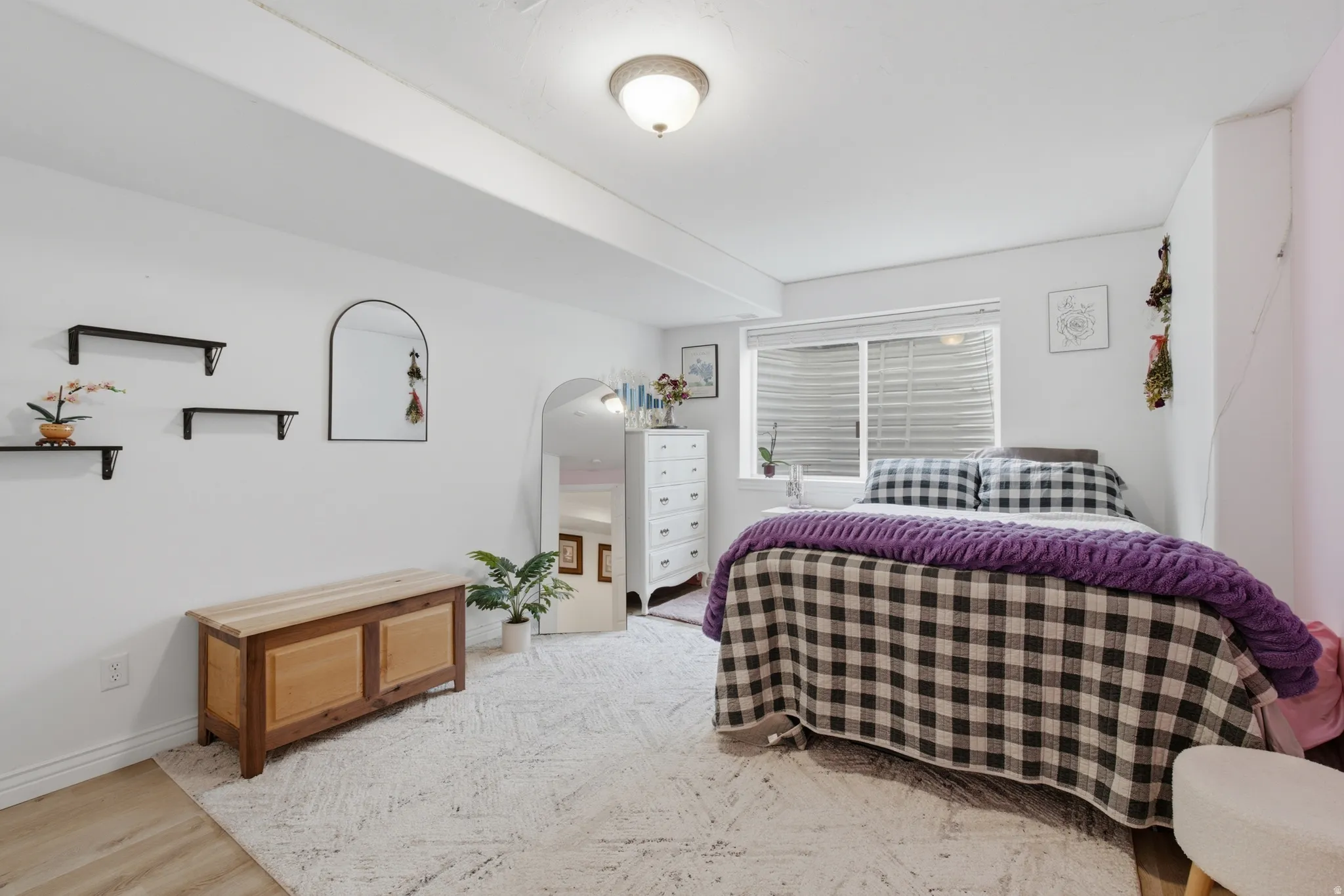 Bedroom featuring wood-finish flooring, a neutral color palette, and a window with blinds