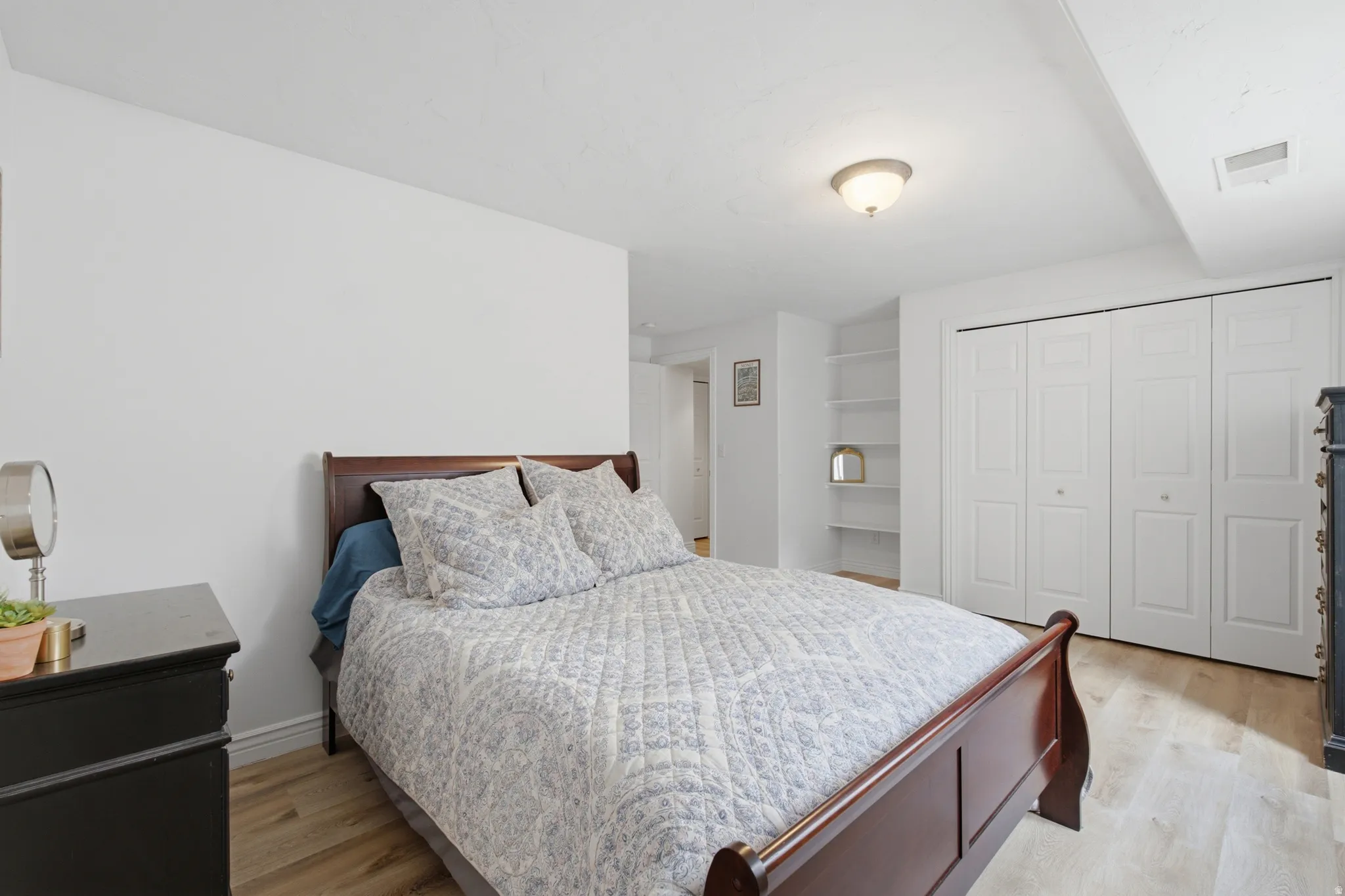 Bedroom featuring wood-finish flooring, recessed lighting, and a built-in shelving unit