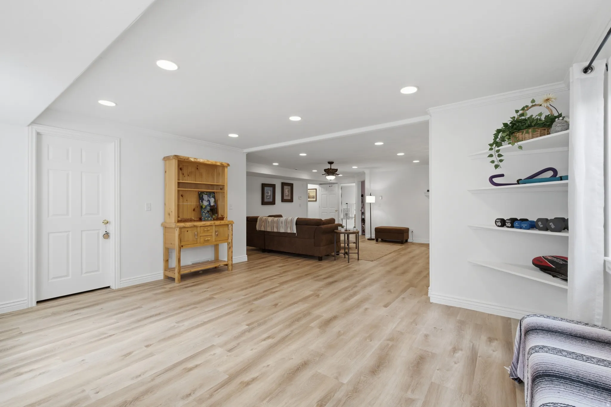 Expansive room featuring wood-finish flooring, recessed lighting, and white walls with baseboards