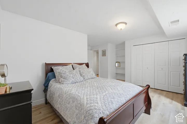 Bedroom featuring wood-finish flooring, recessed lighting, and a built-in shelving unit