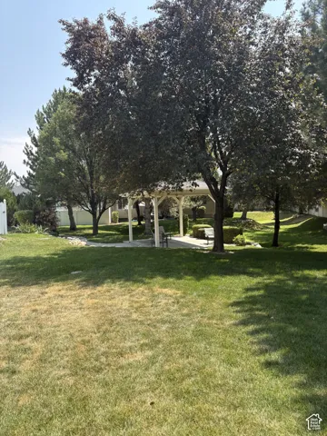 Manicured lawn with mature trees and a white gazebo