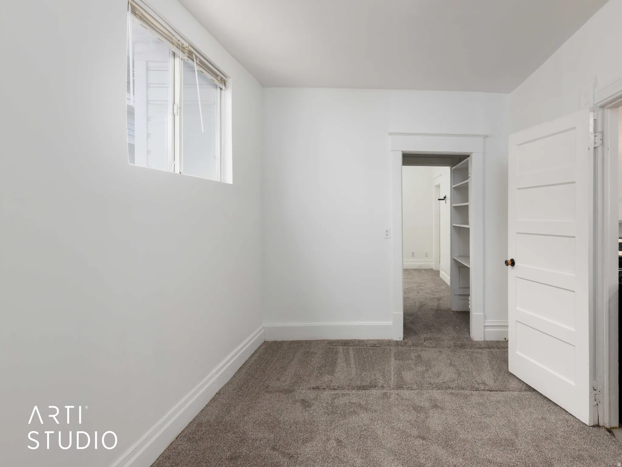 White painted walls, carpeted flooring, window with blinds, paneled interior doors, and a stainless steel range with oven