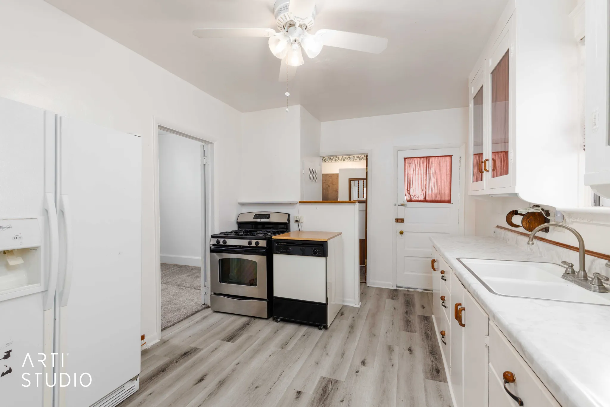 Kitchen featuring wood-finish flooring, white cabinetry, a stainless steel range, and a ceiling fan