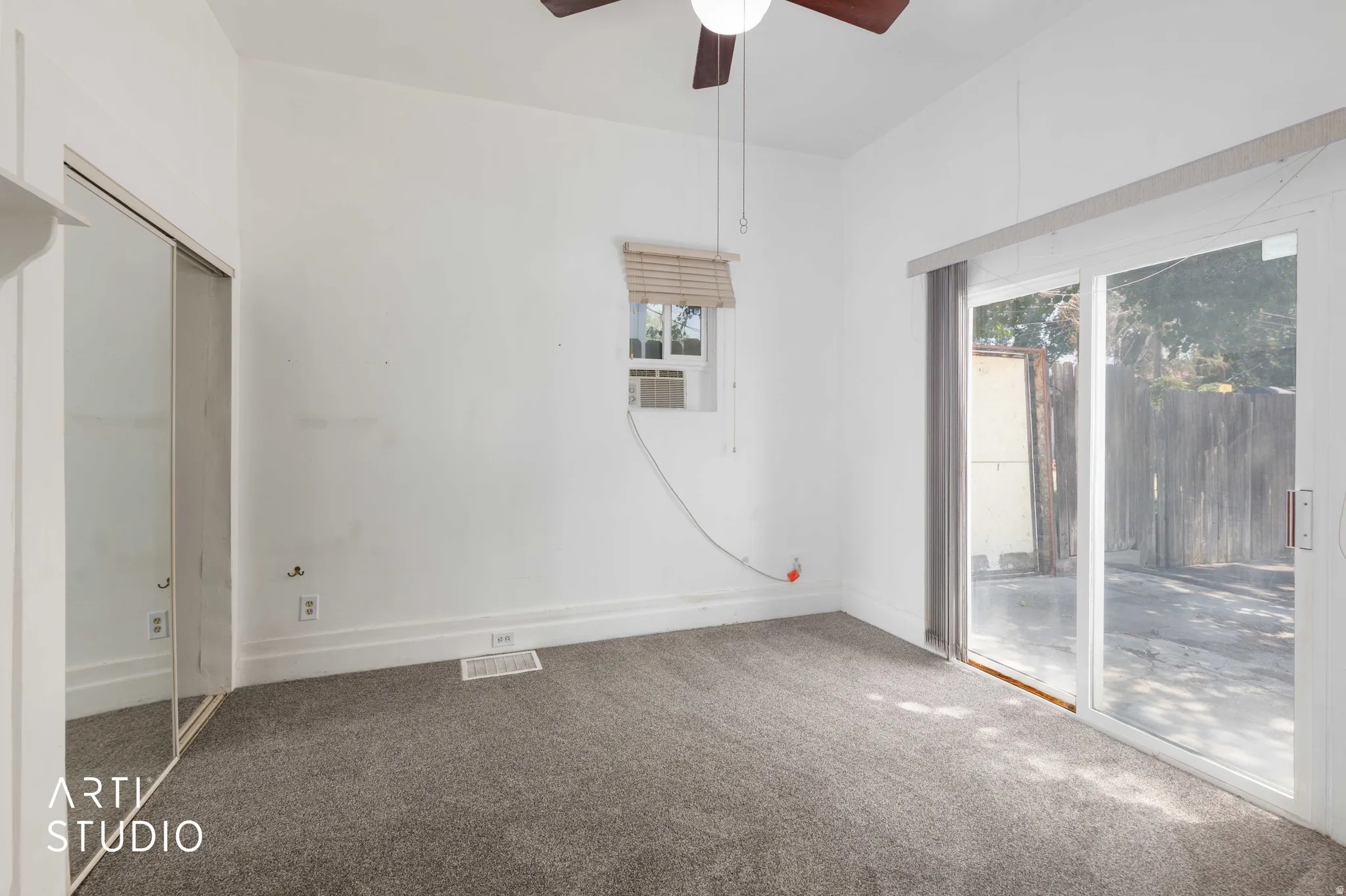 Carpeted flooring, mirrored sliding closet doors, window with horizontal blinds, and a ceiling fan