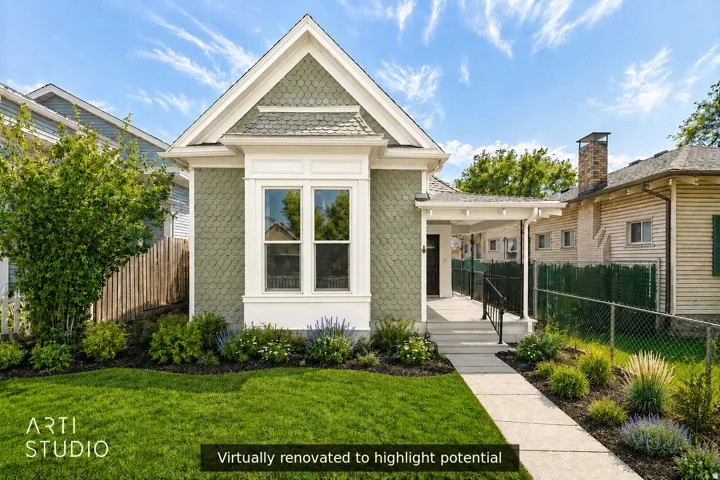Gabled roofline, decorative fish-scale siding, bay window with white trim, covered porch entry, and a manicured lawn