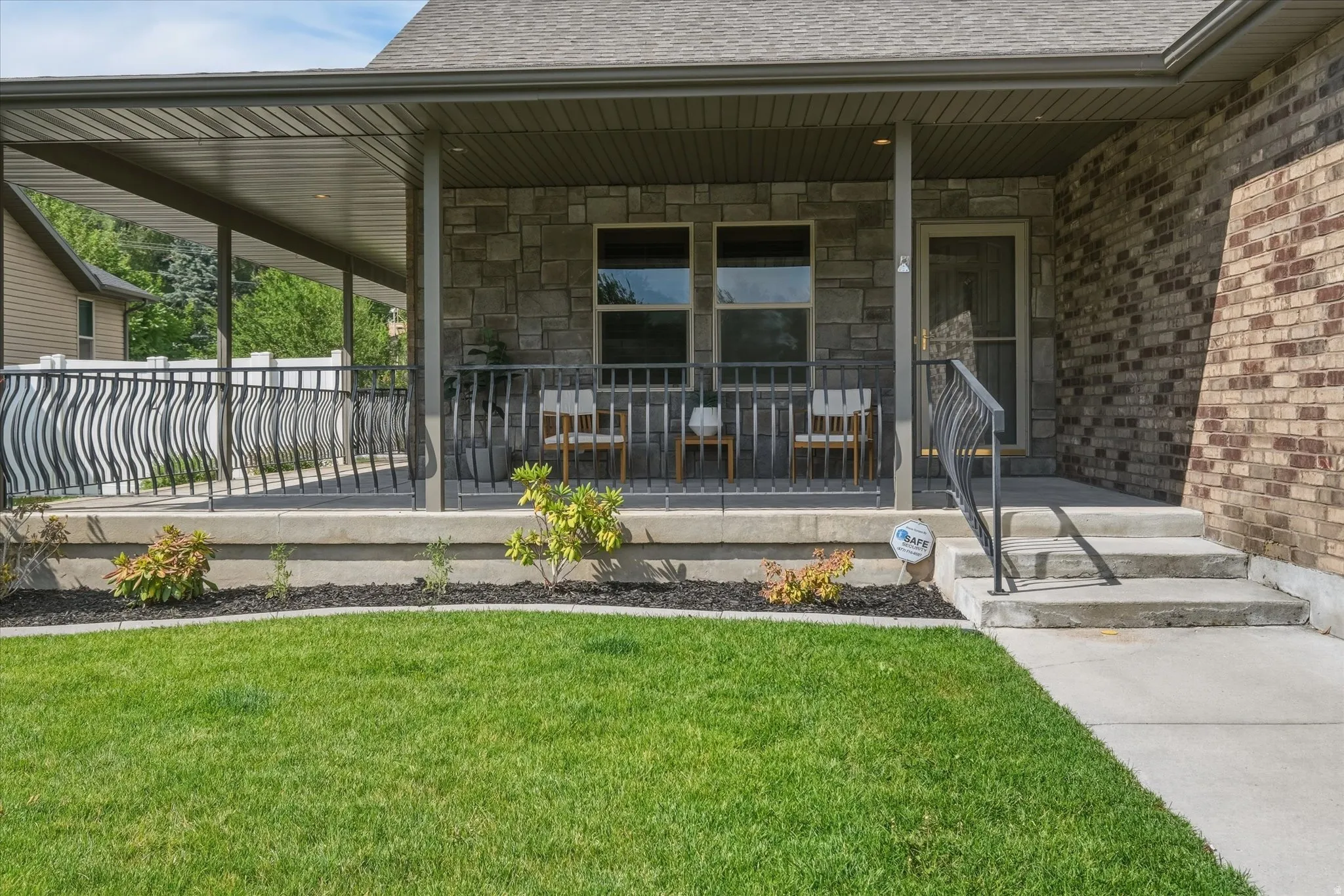 Covered porch entry featuring stone and brick façade accents