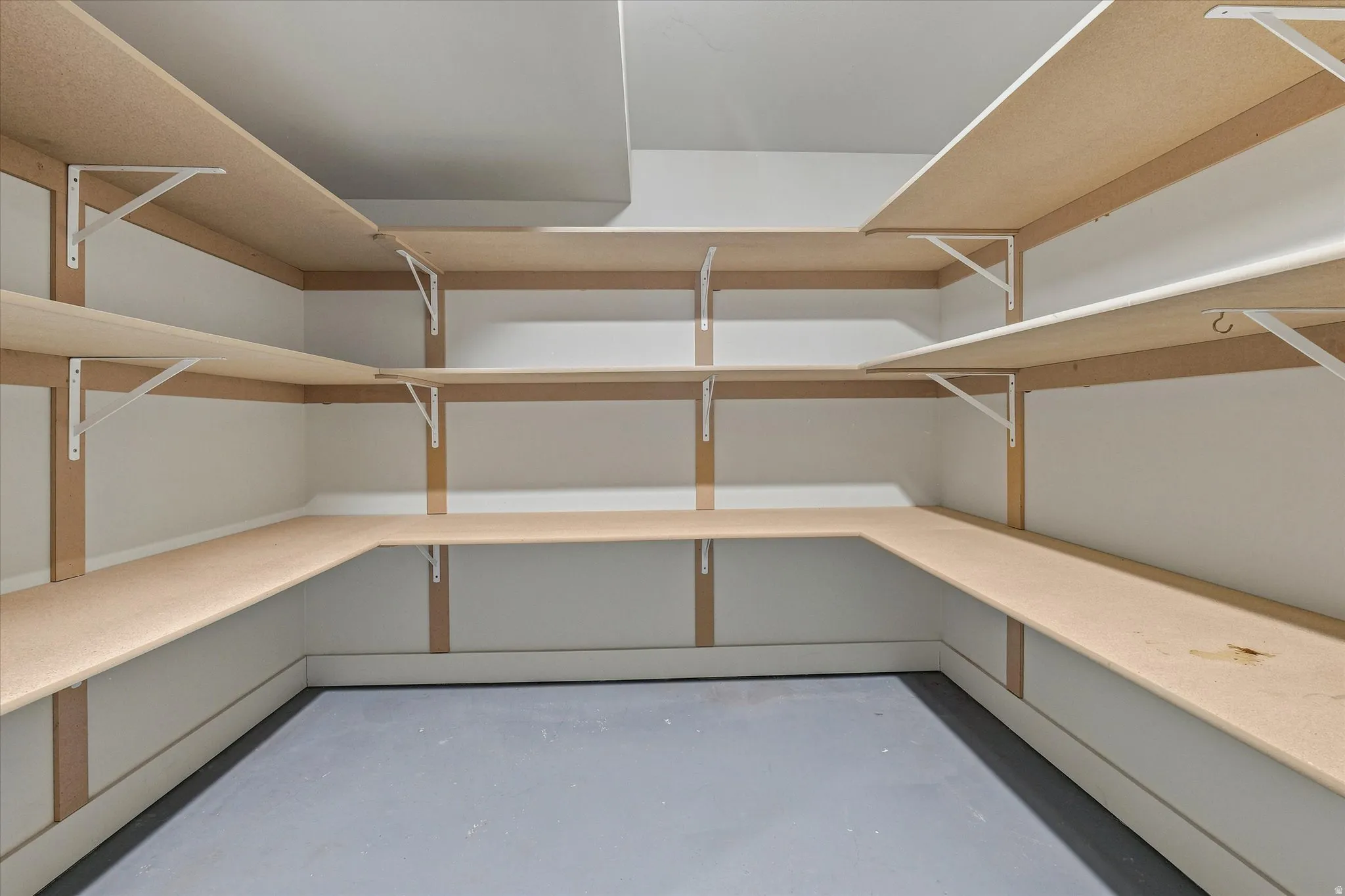 Built-in shelving system with light wood-finish shelving and white wall brackets