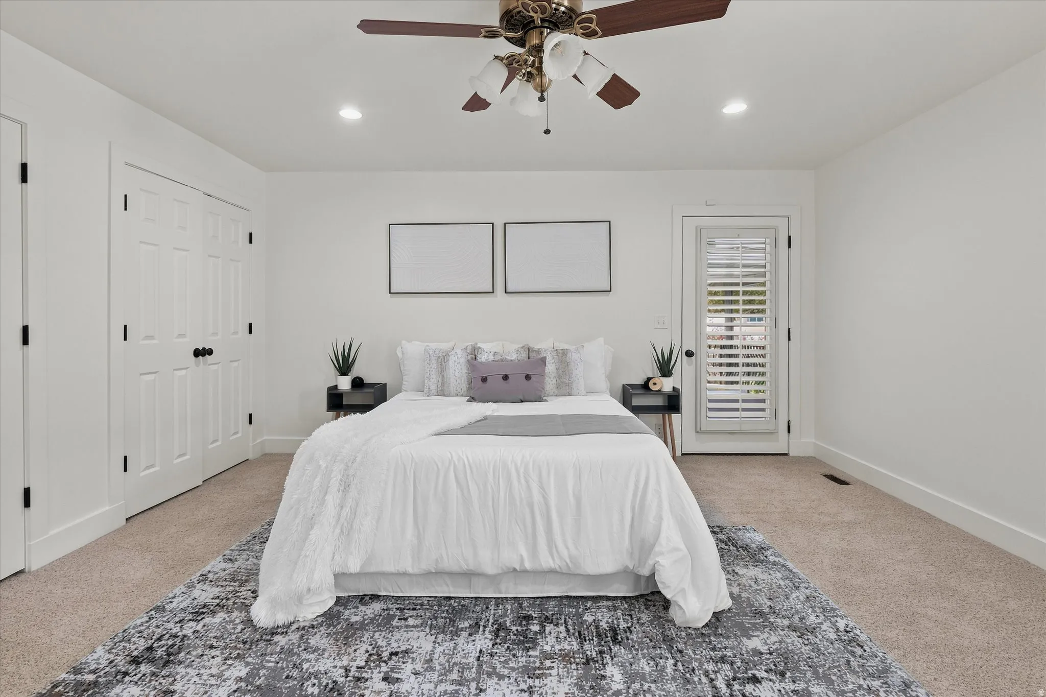 Spacious bedroom featuring neutral carpeting, a ceiling fan with integrated lighting, and recessed ceiling lights