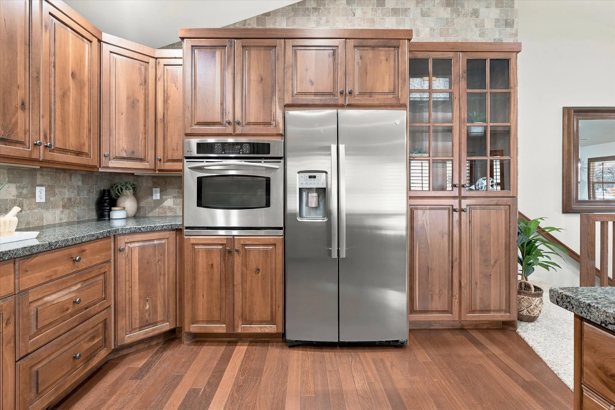 Kitchen featuring wood-finish flooring, granite countertops, and stainless steel appliances