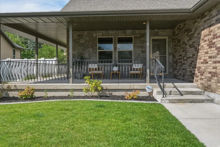 Covered porch entry featuring stone and brick façade accents