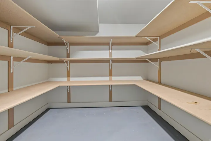 Built-in shelving system with light wood-finish shelving and white wall brackets